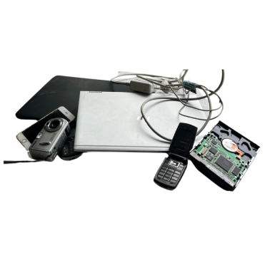 Collection of electronic waste including a laptop, digital camera, flip phone, computer hard drive with visible circuit board, and various connecting cables arranged on a white background. E-waste recycling components displayed for proper disposal.